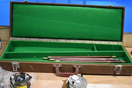A brown Baze covered shotgun case containing 2 cleaning rods with a green interior