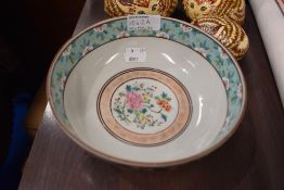 A Chinese porcelain bowl decorated in famille noir with scenes of exotic birds.