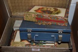 A small sized childrens suitcase with a selection of advertising tins and boxes.