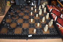 A mid century style chess set in an Isle of Lewis style with large wooden board.