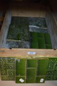 A box of late Victorian Olive green lustre tiles including floral and brick designs.