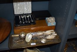 A selection of mother of pearl handle cutlery with additional serving items.