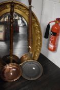 Two antique copper bed warming pans with turned wood handles.
