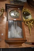 An early 20th century Vienna style wall clock having a glass and mahogany case.