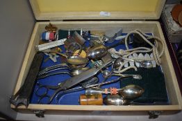 A box of curios and trinkets including a cigar cutter, candle snuffer and Mauchline ware