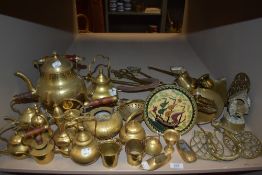 A shelf of vintage brass wares including a collection of kettles and fire side items.