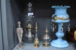 Three art glass scent or perfume bottles with a blue milk glass lustre AF and an oil lamp.