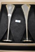 A modern Links London set if silver plated champagne flutes.
