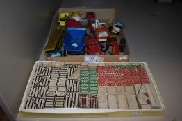 A box of vintage play worn die cast toys with a building block set.