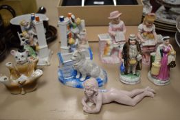 A collection of Victorian Fairings and porcelain figures including a nude piano baby.