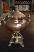A Victorian samovar tea urn with copper body and brass fitments having stag head handles.