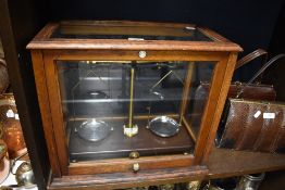 An early 20th century Griffin and Tatlock Chemist or Apothecary scales in a fitted oak and glass