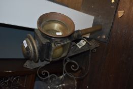 An early 20th century car or carriage lamp with mountable wall bracket.