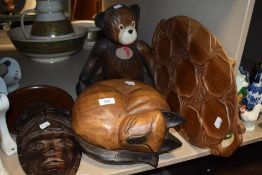 A wooden cat and teddy bear with an Indonesian style mask and a wooden snack tray.