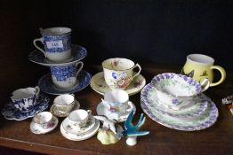 A collection of tea cups including miniature Coalport sets and a hand painted Royal Doulton trio.