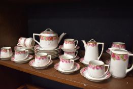 An Early 20th century part tea service un marked in porcelain decorated with roses.