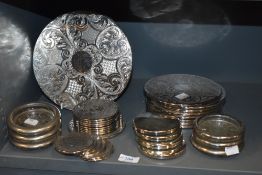 A good selection of silver plated table mats and coasters including a bird set by King.