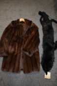 A full length fox stole with a similar full length fur coat.