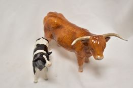 A john Beswick Highland Cow figure study JBF 75 with a Fresian Holstein calf.