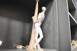 A Nao lamp base of a Romeo style lover with rose leaning against a tree, 45cm tall.