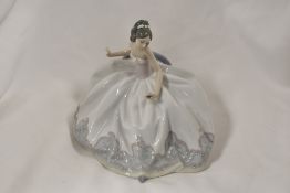 A Lladro figurine study of a seated girl in ball gown no.5859