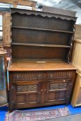 A vintage Priory style dresser base and side board in a medium stain.