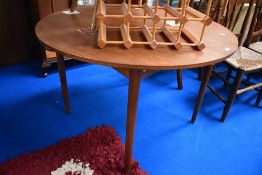 A mid century teak circular extending dining table.