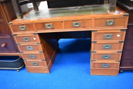 A modern campaign style pedestal desk with two sets of five drawers and one central,.