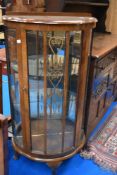 A bow fronted display case with glazed doors.