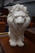 A plaster cast figure of a pensive lion. 60cm tall approx.