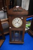 An Edwardian oak cased wall mounted clock.