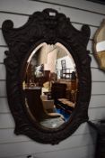 A Victorian Arts and Crafts oak carved mirror with a Green man design and foliate border.