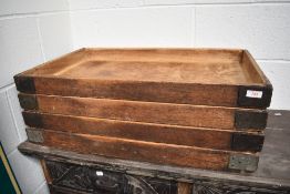 A stack of four vintage bakers bread trays.