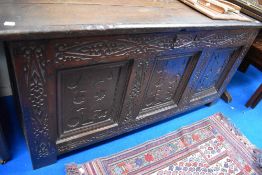An early Victorian oak coffer with carved front and plank top.