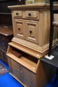 A modern golden oak bed side cupboard with drawer.