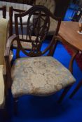 An early 20th Century mahogany armchair having overstuffed seat and shield back