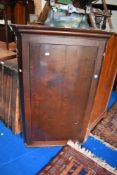 A Victorian corner cupboard in oak.