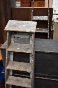 Two pairs of vintage step ladders.