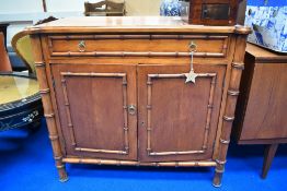 A modern Beech wood cabinet with drawer having Bamboo effect details.
