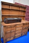 A traditional dark stained Ercol or similar kitchen dresser