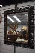 A Victorian Gothic mirror with highly carved foliate frame work.