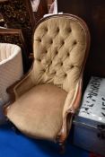 A Victorian nursing chair with button back and carved frame work.