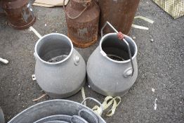 Two stainless steel milk creamers.