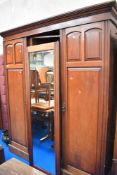 An antique mahogany three part wardrobe with fitted interior.