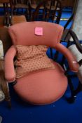 A Victorian mahogany low seat armchair with turned frame and later upholstery