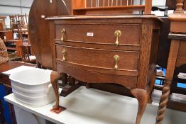 An Edwardian oak side table with two drawers on cabriole legs.