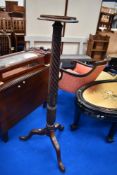 A large Victorian Torchere stand having carved frame work.
