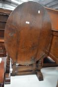 An 18th century oak tilt top tea table with plank top and turned legs.