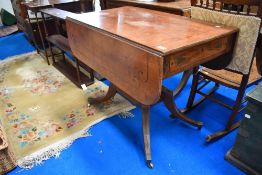 A Victorian tea table in an Aesthetic style with drop leaf and under drawers