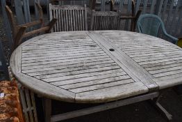 A large teak garden table withfour fold away chairs and an additional Hexagonal fold away teak